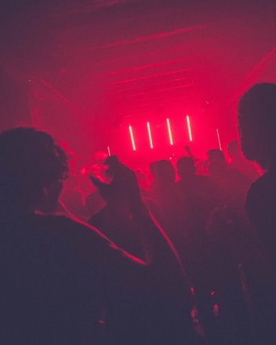 Crowd dancing under red neon lights