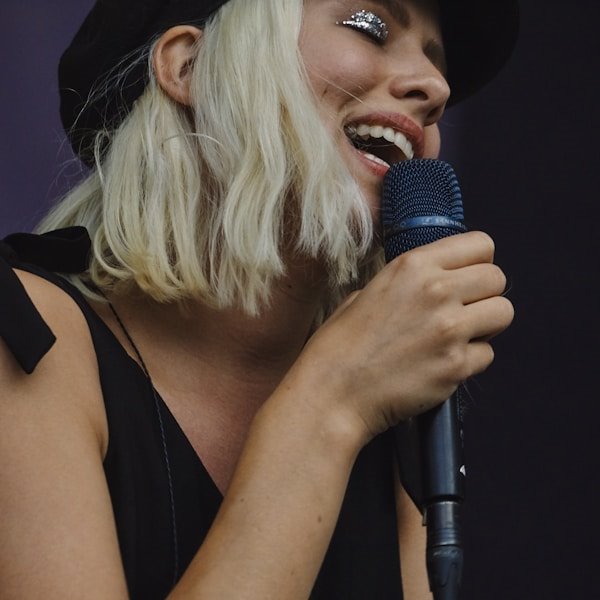 Singer with glitter makeup performing into a microphone
